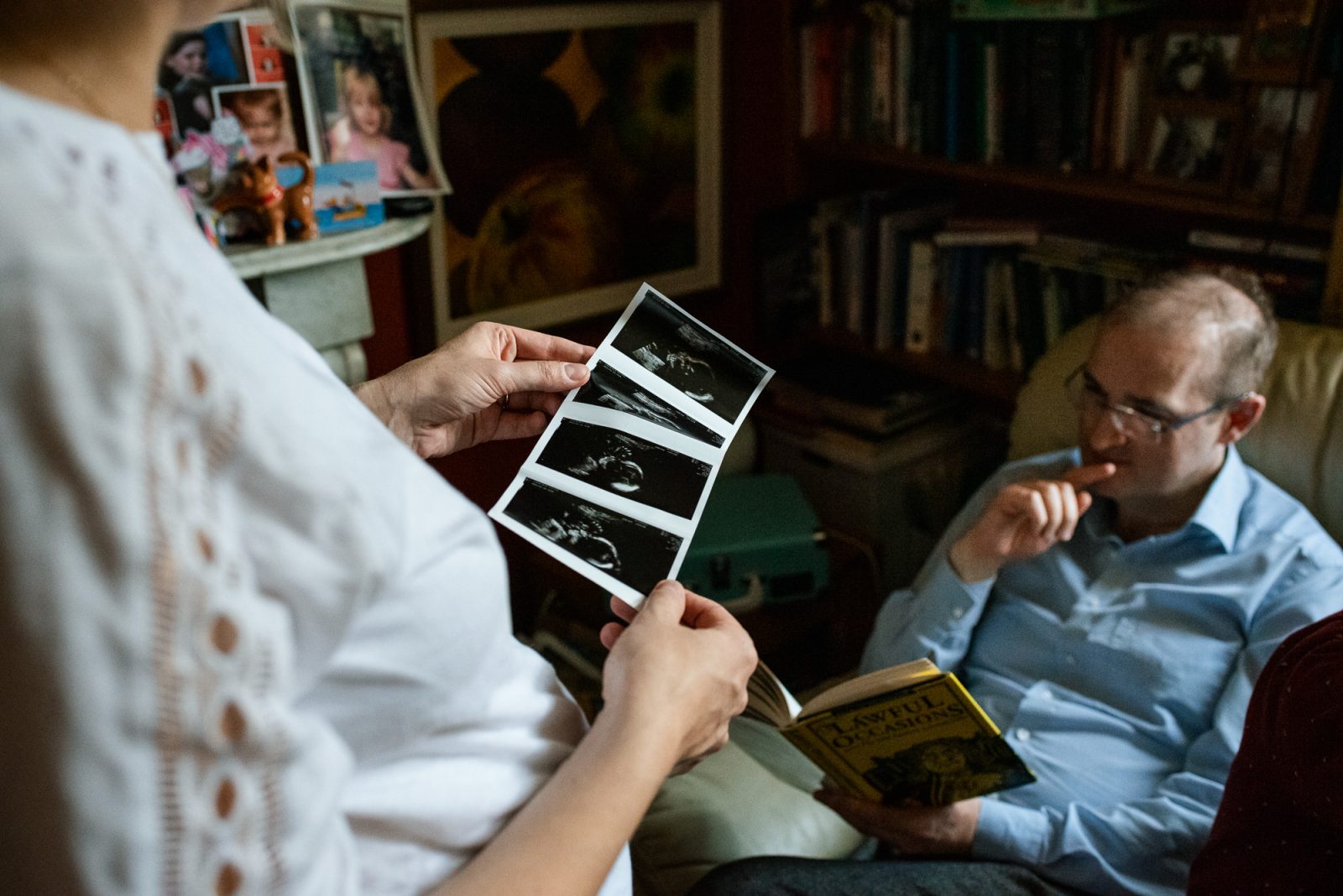 Couple discussing ultrasound images at home.