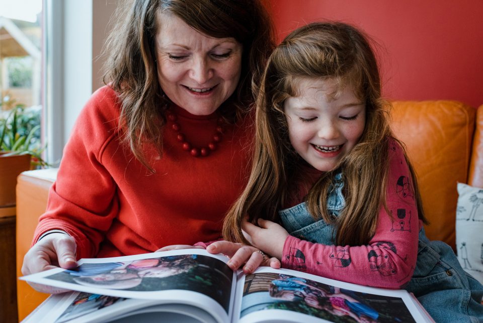 Woman and child enjoying a photo album together.
