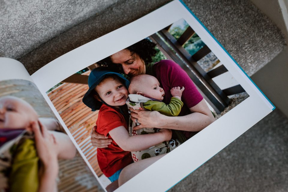 Mother embracing two children, family photo album.