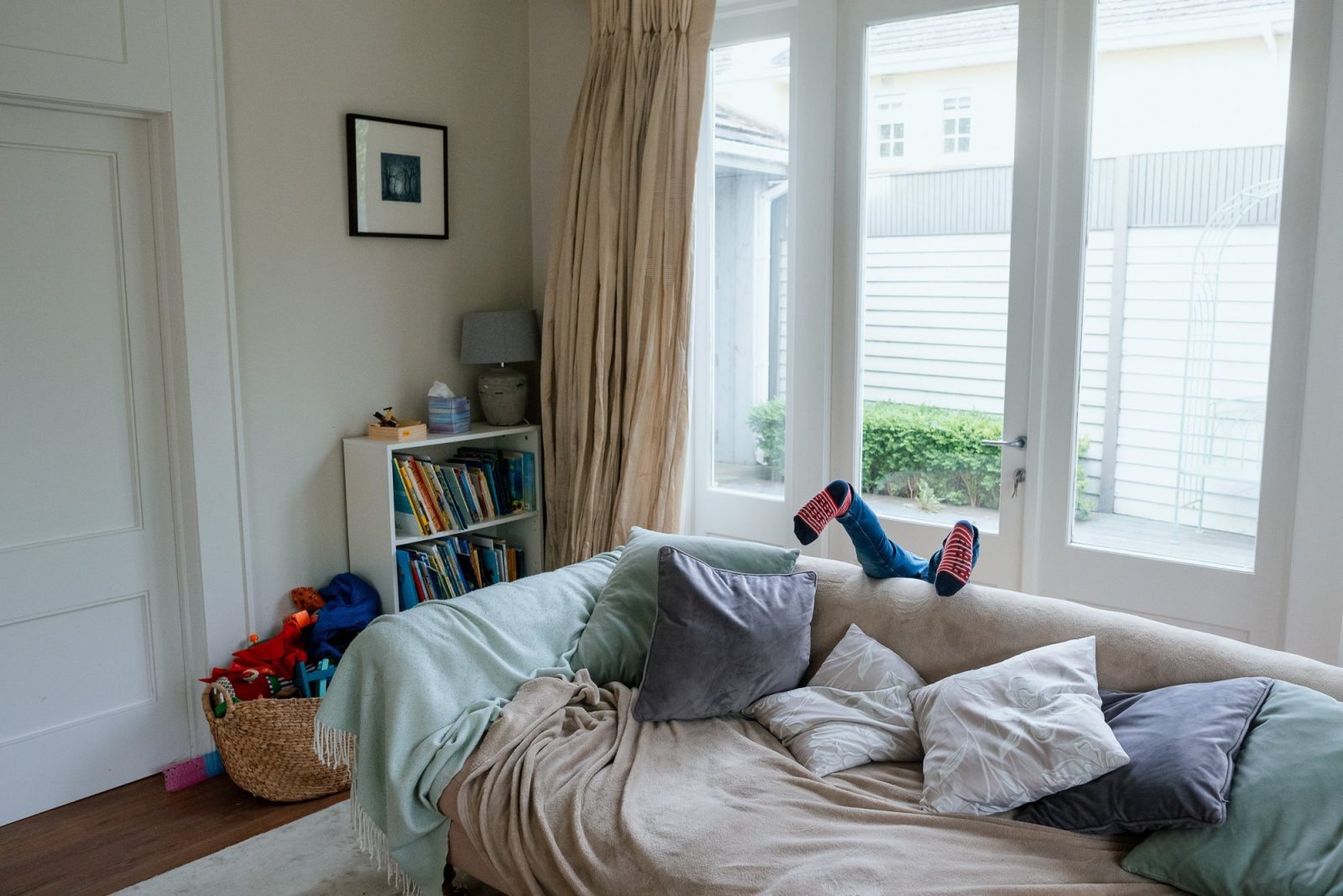 Child falling off a sofa in a cozy living room.