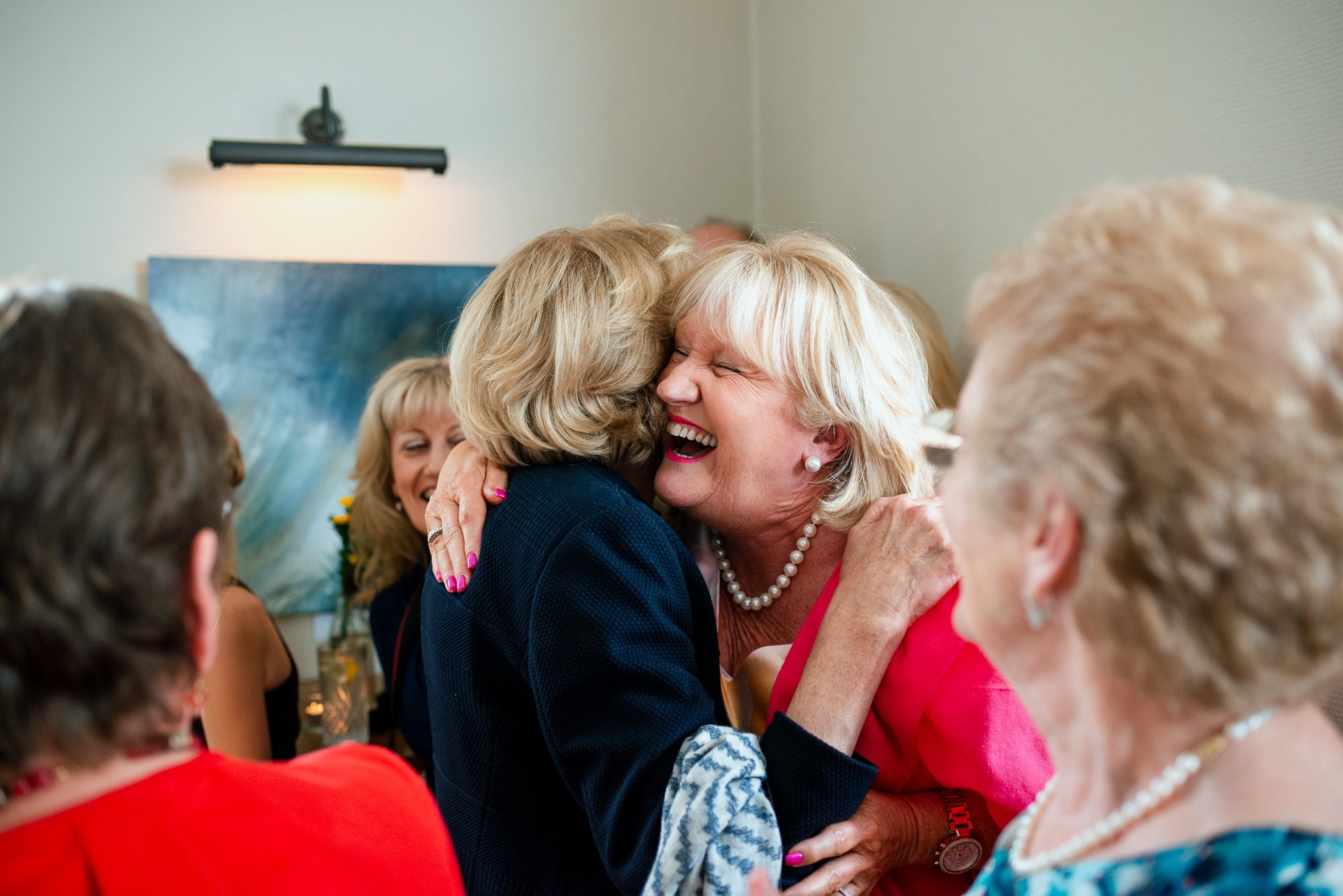 Joyful reunion of elderly women hugging.