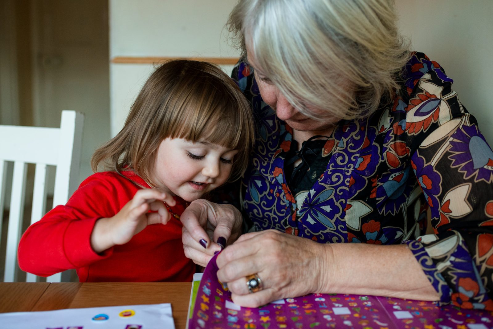 Grandmother and child enjoying crafts together at home.